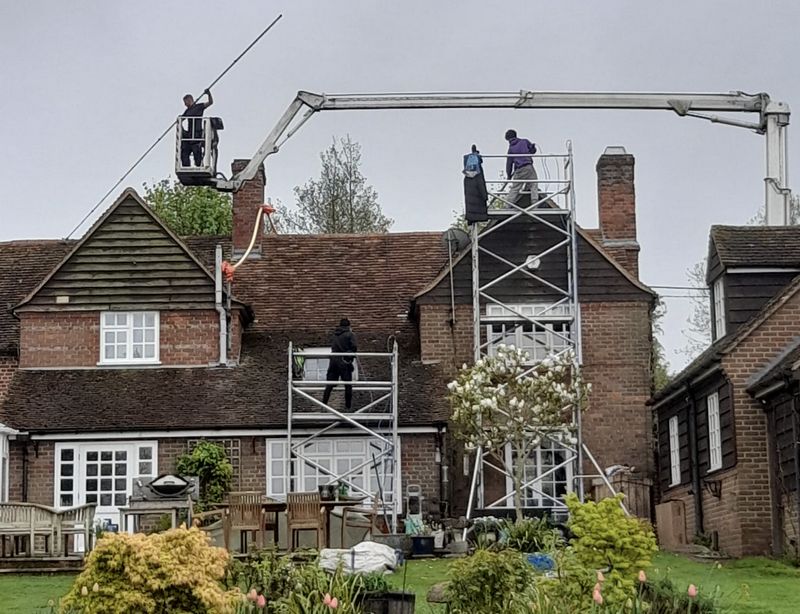 The Moss Cleaners using cherry picker and scaffolding to clean roof safely and professionally in Denmead, Hampshire